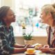 two women sitting at a table, deep in conversation about How To Talk To Anyone