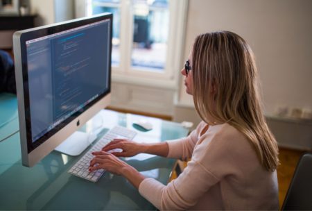software developer coding on desktop computer
