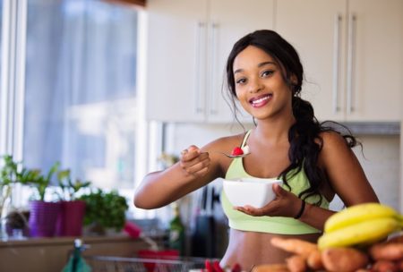 woman in green sports bra eating healthy food