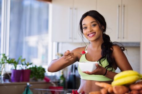 woman in green sports bra eating healthy food