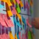 a man in a suit examines a wall covered with colorful post-it notes, reflecting agile scrum user story planning