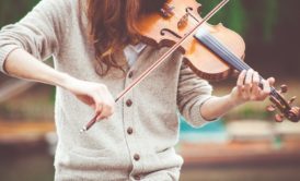 A person learning How to Play the Violin with a bow, creating beautiful music