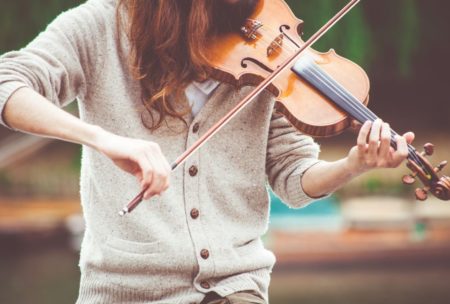 A person learning How to Play the Violin with a bow, creating beautiful music