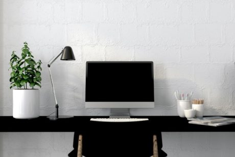 Work area organization showcased in a tidy setup with a black desk, computer, and chair for enhanced productivity.