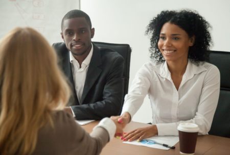 applicant shaking hands with hiring managers in job interview