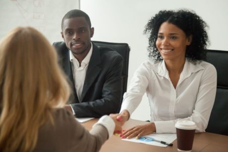 applicant shaking hands with hiring managers in job interview