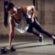 woman doing plank while holding dumbbells