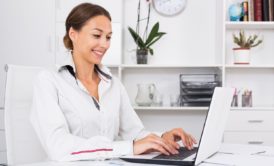 woman typing on white laptop