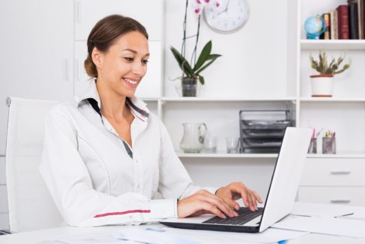 woman typing on white laptop