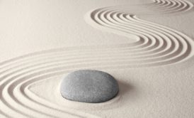 stone and zen circles on white sand