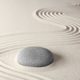 stone and zen circles on white sand