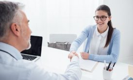 applicant shaking hands with hiring manager job interview