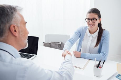 applicant shaking hands with hiring manager job interview