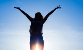 woman raising both hands to sky