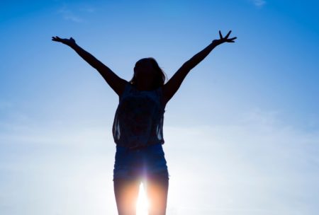 woman raising both hands to sky