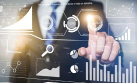 a businessman gestures towards data displayed on a virtual screen, illustrating analytics from advanced power bi