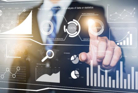 a businessman gestures towards data displayed on a virtual screen, illustrating analytics from advanced power bi
