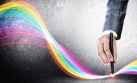 man holding pen and drawing rainbow