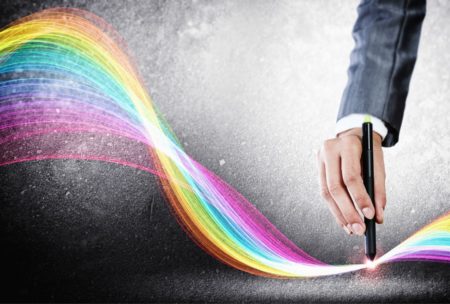 a professional in a suit uses a pen to create a vibrant rainbow line, showcasing CorelDRAW for beginners
