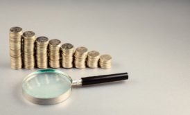 magnifying glass and stacks of coins