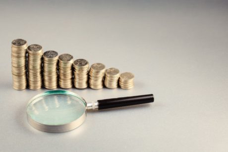 magnifying glass and stacks of coins