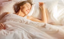 woman smiling sleeping on bed