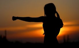 silhouette of strong woman punching