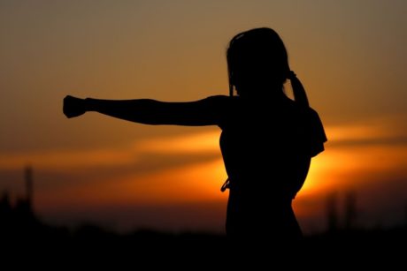 silhouette of strong woman punching