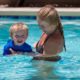 mom teaching toddler how to swim