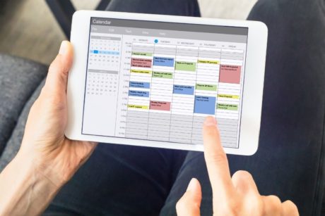 person using time management app on tablet device