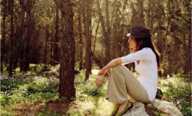 woman sitting on top of big rock