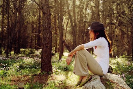 woman sitting on top of big rock