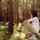 woman sitting on top of big rock