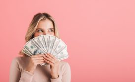 woman in pink sweater holding paper bills