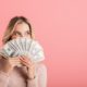 woman in pink sweater holding paper bills