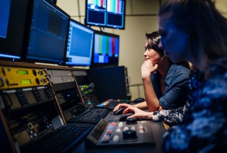 two people editing a broadcast using adobe premiere