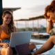 female digital nomad in orange bikini working while on vacation