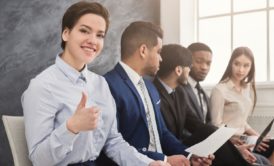 female job applicant smiling and making a thumbs up