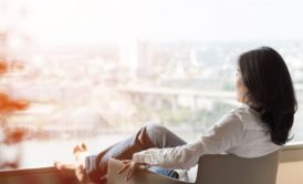 woman relaxing on lounge chair looking at view of the city