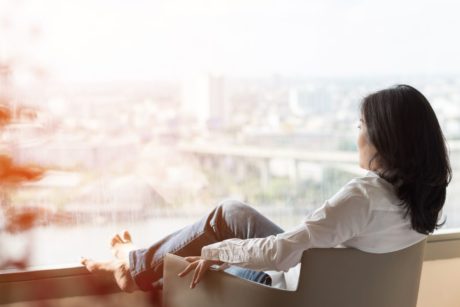 woman relaxing on lounge chair looking at view of the city