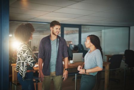 three colleagues engaged in a discussion in an office, demonstrating emotional intelligence in relationships