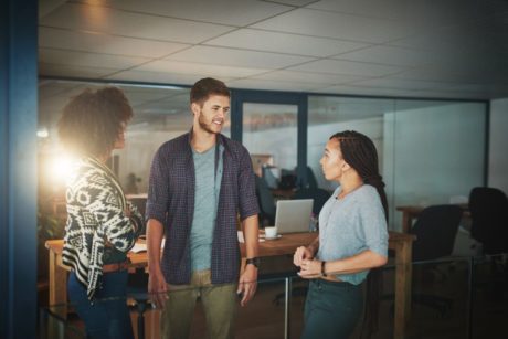 three colleagues engaged in a discussion in an office, demonstrating emotional intelligence in relationships