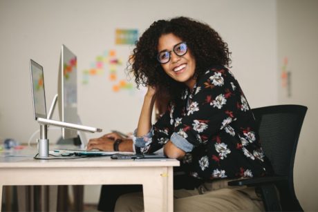 woman smiling from work desk excel magic 8