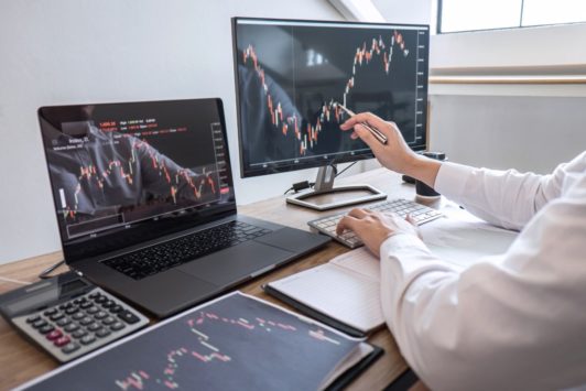 man tracking iq stock options using desktop and laptop computers