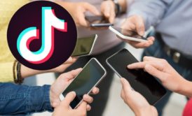 tiktok logo and group of people holding smartphones