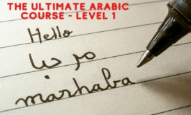 person writing arabic greeting marhaba on paper