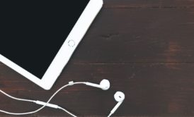 tablet and earphones on wooden table, used for iPad music production
