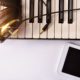 electronic keyboard headphones and white smartphone on white table top