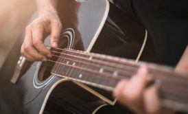 man playing black acoustic guitar