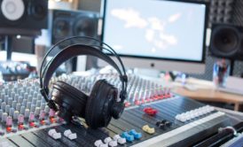 headphones on top of mixer in music production studio